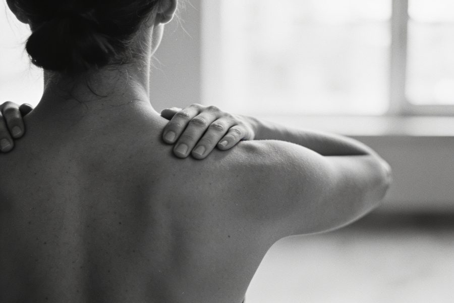 Mulher de costas em exercício de respiração, ambiente calmo